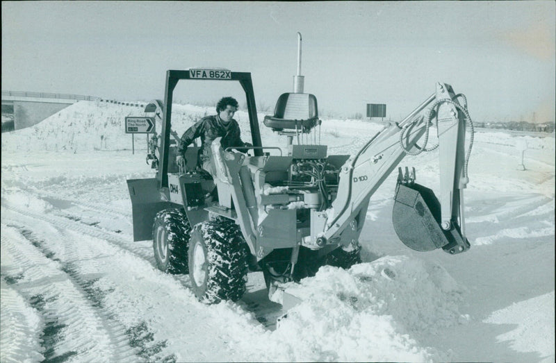 A man clears a path through the snow using a trencher. - Vintage Photograph