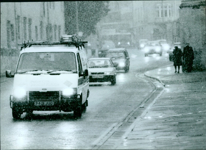 Heavy traffic in Oxford, England, as snow accumulates. - Vintage Photograph