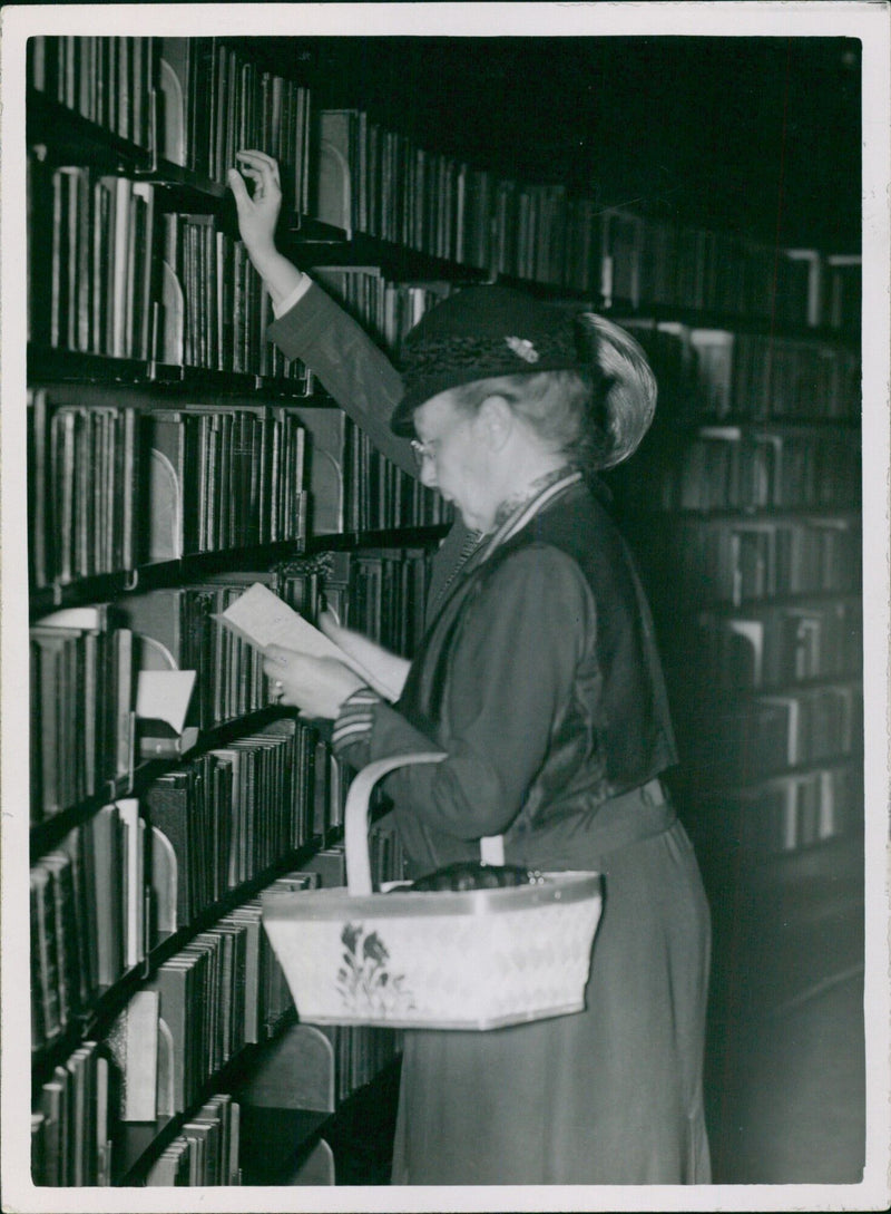 Two women peruse books at the Steelun Stahbibliotekat library in Stockholm, Sweden in 1935. - Vintage Photograph