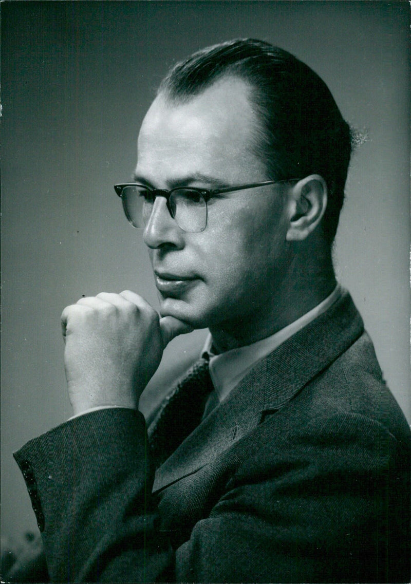 David Farquhar, Senior Lecturer in Music at Victoria University in Wellington, New Zealand, poses with a copy of his publication "Ring Round the Moon" in 1956. - Vintage Photograph