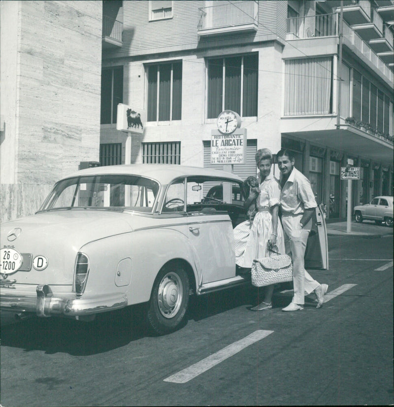 In Naples, Italy, customers enjoy the panoramic view and excellent cuisine at Ristorante Le Arcate while Margit at the art gallery looks on. - Vintage Photograph