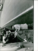 A man is seen walking on a street in Stockholm, Sweden on June 21, 1961. - Vintage Photograph