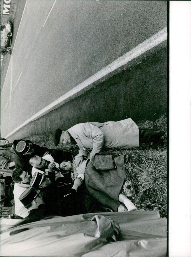 A man is seen walking on a street in Stockholm, Sweden on June 21, 1961. - Vintage Photograph