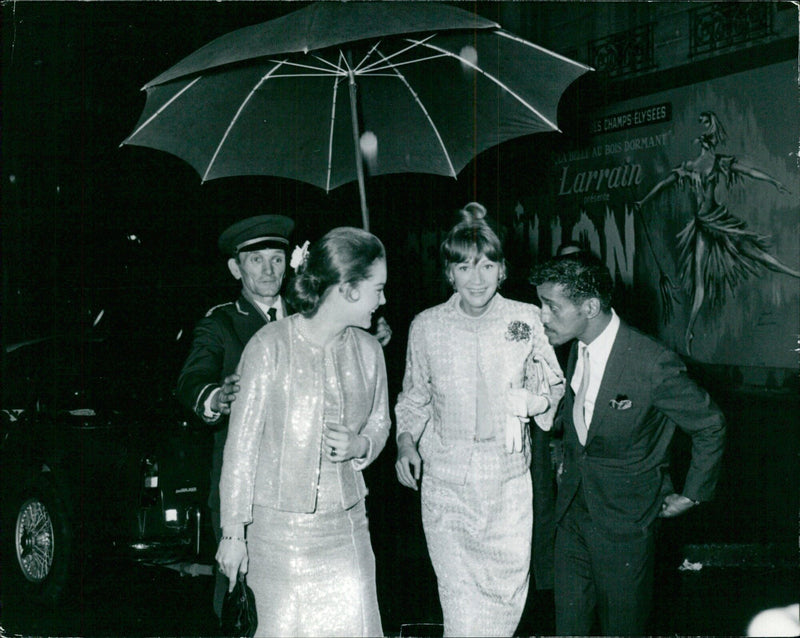 French actor Jean Larrain presents an international magazine to the crowd on the Champs Elysees in Paris, France on April 23, 1964. - Vintage Photograph