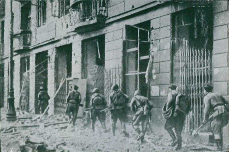 Russian machine gunners advance through the destroyed streets of Praga, an industrial suburb of Warsaw, Poland in 1944. - Vintage Photograph