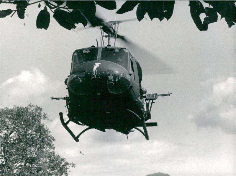 A Salvadorean army helicopter evacuates a war injured patient from the conflict zone in the north-east of the country to a hospital in the south-east. - Vintage Photograph