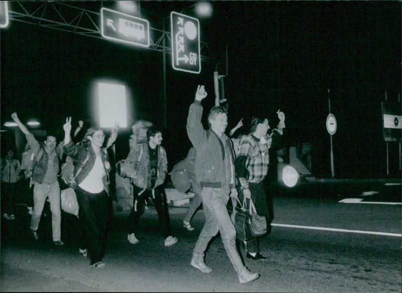 East Germans wave happily as they cross the Hungarian border into Austria, beginning their exodus to West Germany in September 1989. - Vintage Photograph