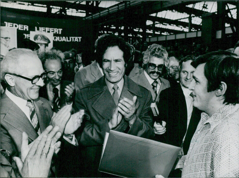 Colonel Gadafy of Libya grins broadly and claps during a visit to the Marzahn Machine Tool Factory in East Berlin, alongside East German leader Erich Honecker in June 1978. - Vintage Photograph