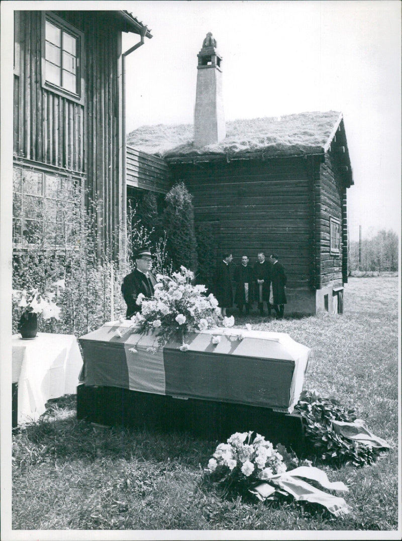 Knis Karl Aronson of Leksand stands as an honor guard in front of Hugo Alfvén's grave in Tibble, Sweden, on May 15, 1960, as members of Leksands Spelmanslag pay their respects. - Vintage Photograph