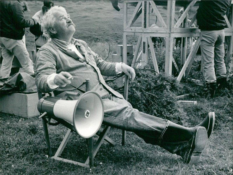 Actor Hasse Alfredson contemplates the weather while taking a break from filming Vargens Tid in Sweden. Photo: Göran Tonström/TT-Bild. - Vintage Photograph