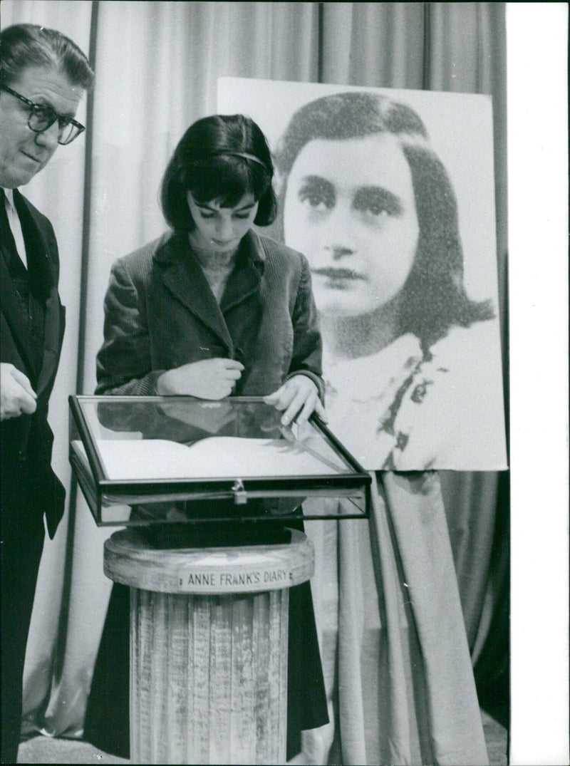 Millie Perkins reads a passage from Anne Frank's diary at the Anne Frank House in Paris. - Vintage Photograph