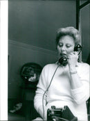 A model poses in a fashion ensemble designed by Rhe Pierre-Charron during a photoshoot in Paris, France. - Vintage Photograph