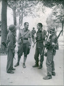 French Forces of the Interior fighters celebrate the liberation of Paris on August 25, 1944, armed with bazookas, hand grenades, rifles, and revolvers and wearing a variety of headgear. - Vintage Photograph