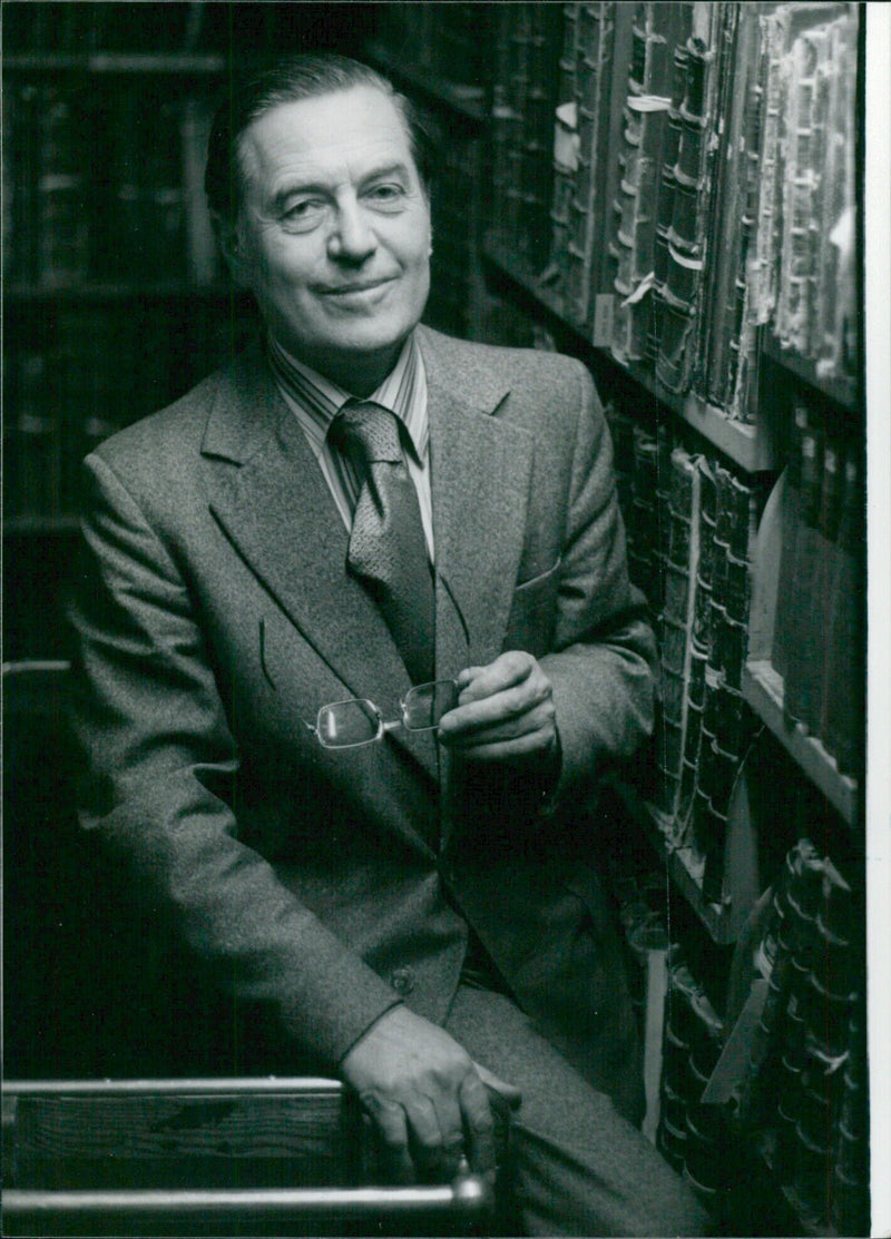 Alexander Wilson, newly appointed Director-General of the British Library Reference Division, stands in front of the nation's largest collection of books. - Vintage Photograph