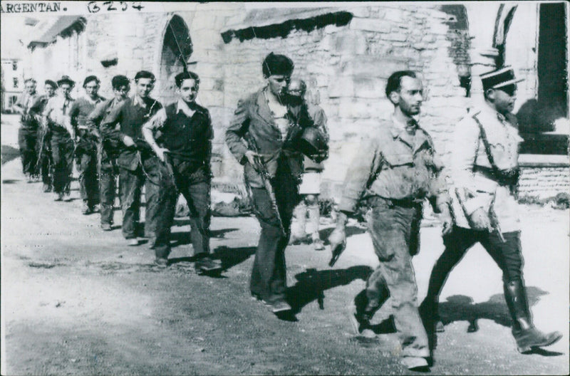 French Maquis forces march into Argentan, France to liberate the city from German occupation on August 8, 1944. - Vintage Photograph