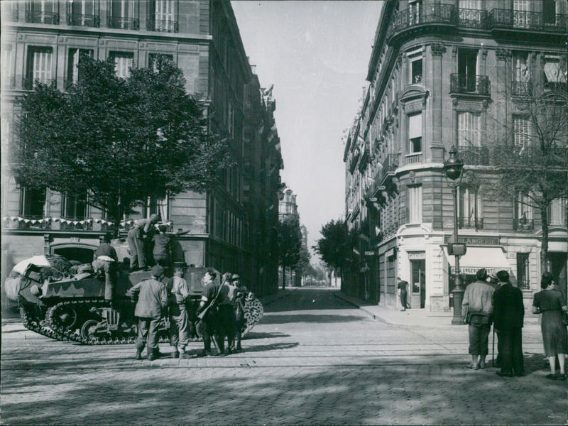 A French tank advances in Paris to blast a German road block during the liberation of the French capital on August 25, 1944. - Vintage Photograph