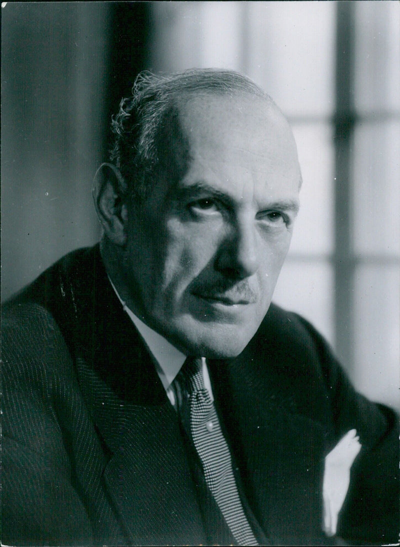 British Secretary of State for the Colonies, the Rt. Hon. Oliver Lyttelton, M.P., is photographed in a portrait study taken by Baron and distributed by Camera Press London. - Vintage Photograph