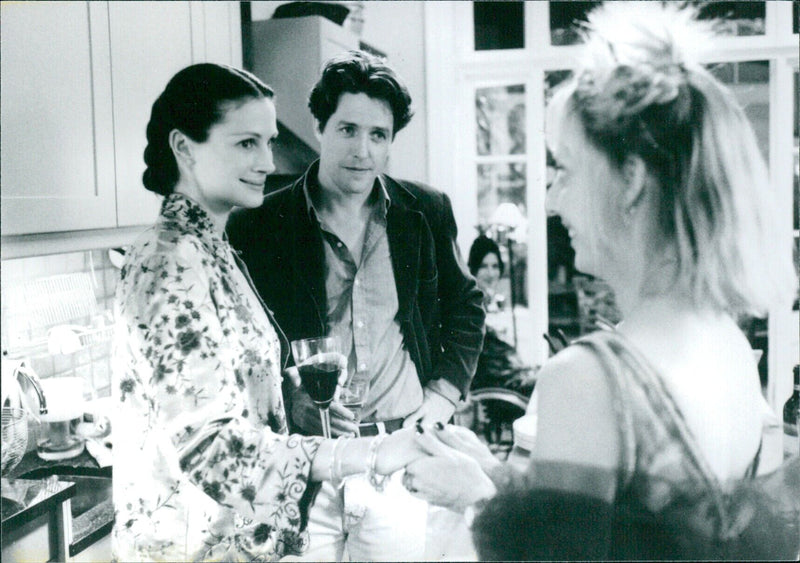 Actors Julia Roberts, Hugh Grant, and Emma Chambers are seen attending the premiere of their film "Notting Hill" in London, England. - Vintage Photograph