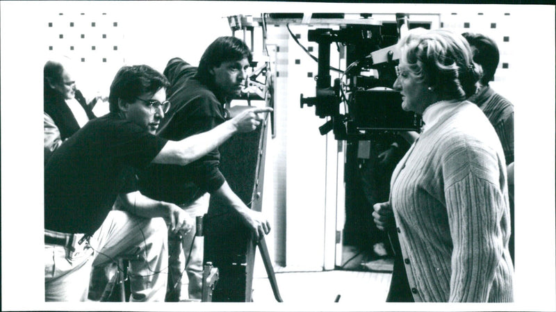 Actor Robin Williams dressed as Mrs. Doubtfire greets director Chris Columbus on the set of the 1993 hit comedy "Mrs. Doubtfire". - Vintage Photograph