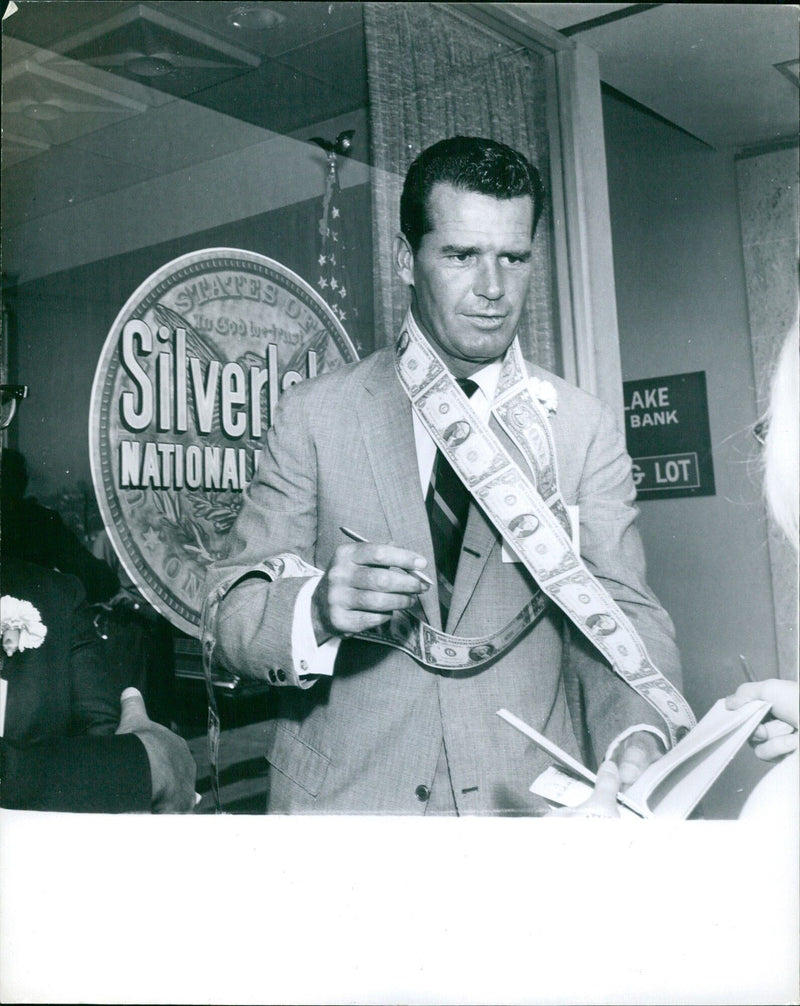 Jauns Garker, a resident of Moscow, Russia, stands outside the entrance to the National Bank of Sweden in Stockholm, Sweden on April 21, 1964. - Vintage Photograph