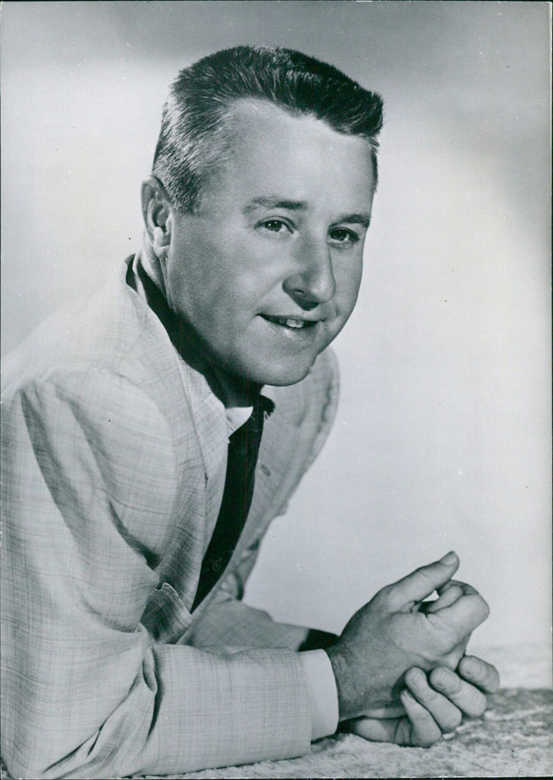 Comedian George Gobel smiles and plays the guitar on a National Broadcasting Company television programme. - Vintage Photograph