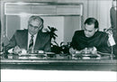 Indian Prime Minister Rajiv Gandhi and Soviet President Mikhail Gorbachev sign a joint trade and weapons co-operation treaty during Gorbachev's visit to India on November 20th, 1988. - Vintage Photograph