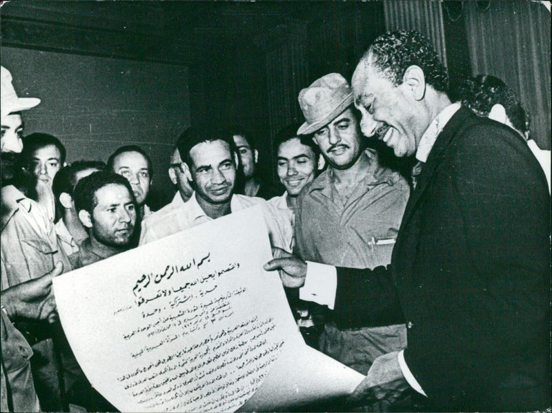 President Sadat of Egypt accepts a document "written in Arab blood" from 5,000 Libyan "unity marchers" during a demonstration on the Egyptian border on September 1, 1973. - Vintage Photograph