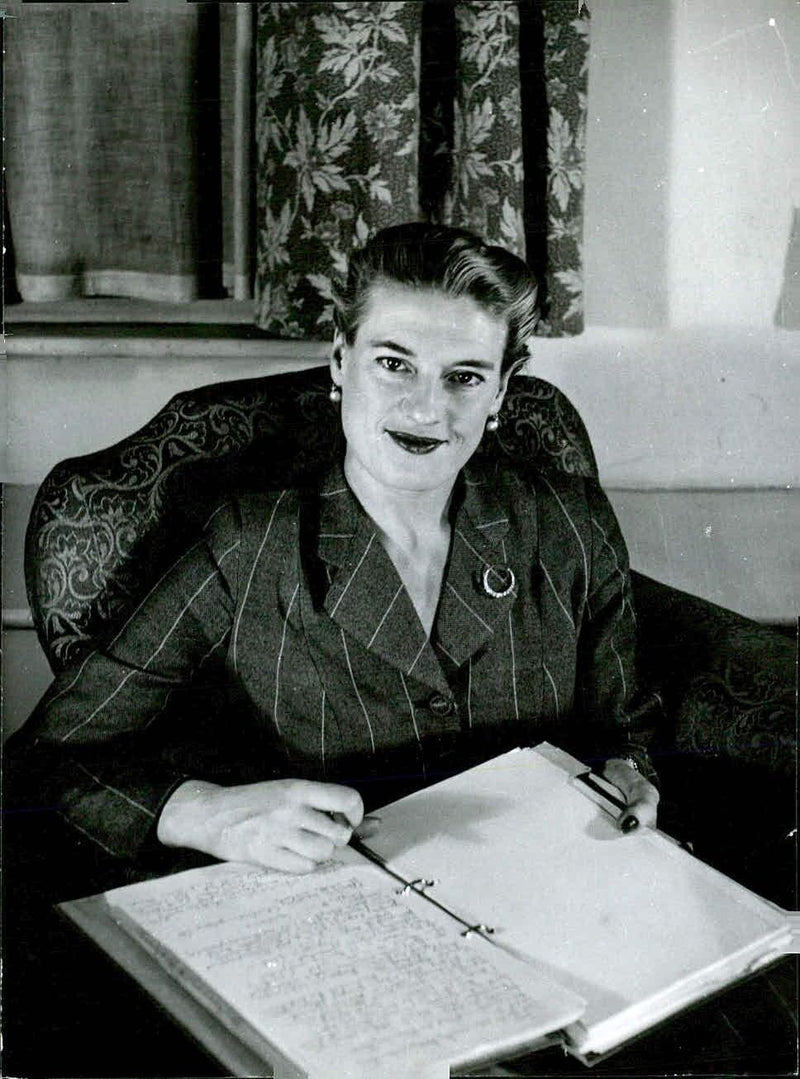 Heather Jenner, Head of the Bond Street Marriage Agency, poses for a portrait taken by photographer Tom Blau. - Vintage Photograph