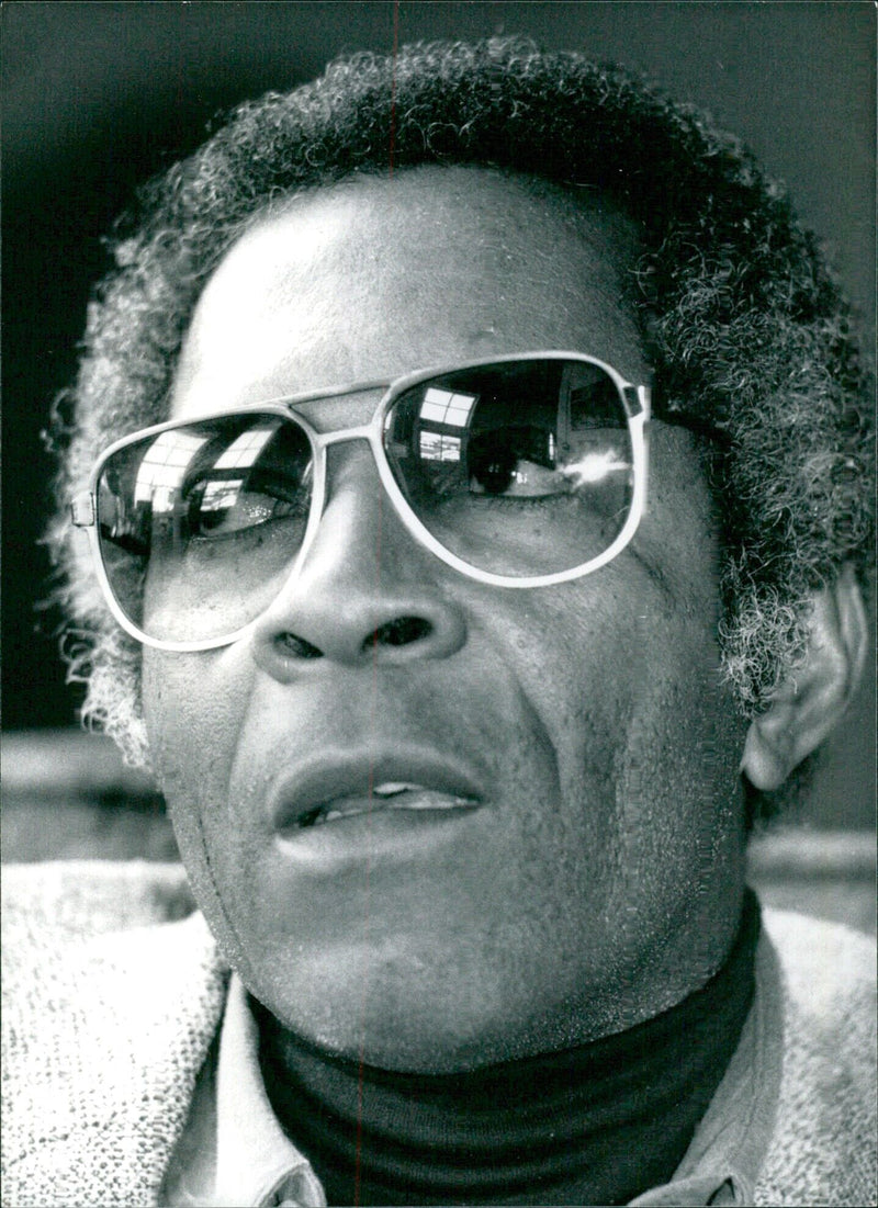 Legendary Jamaican playwright and screenwriter Trevor Rhone poses for a photograph in 1983. - Vintage Photograph