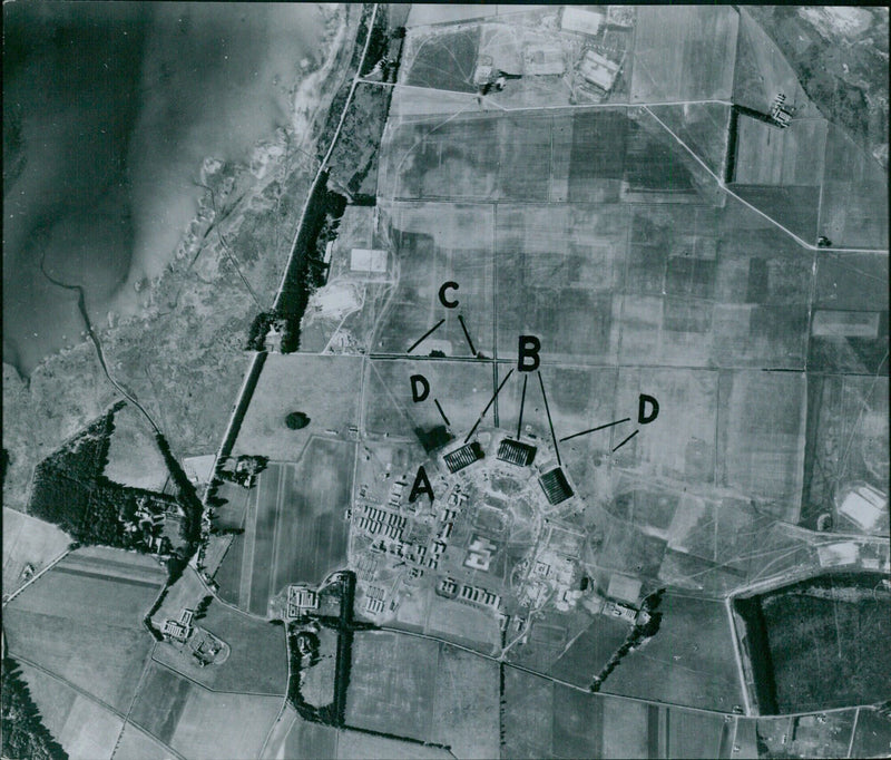 Aerial photograph of Kinloss Airbase in Scotland, taken in 1929, showing the large barracks (A), camouflaged hangars (B) and ready aircraft (D). - Vintage Photograph