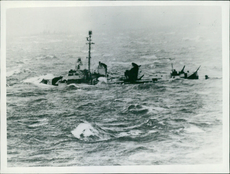 A U.S. destroyer is seen battling rough seas in the Pacific, as massive waves threaten to submerge the vessel on June 30th, 1945. - Vintage Photograph