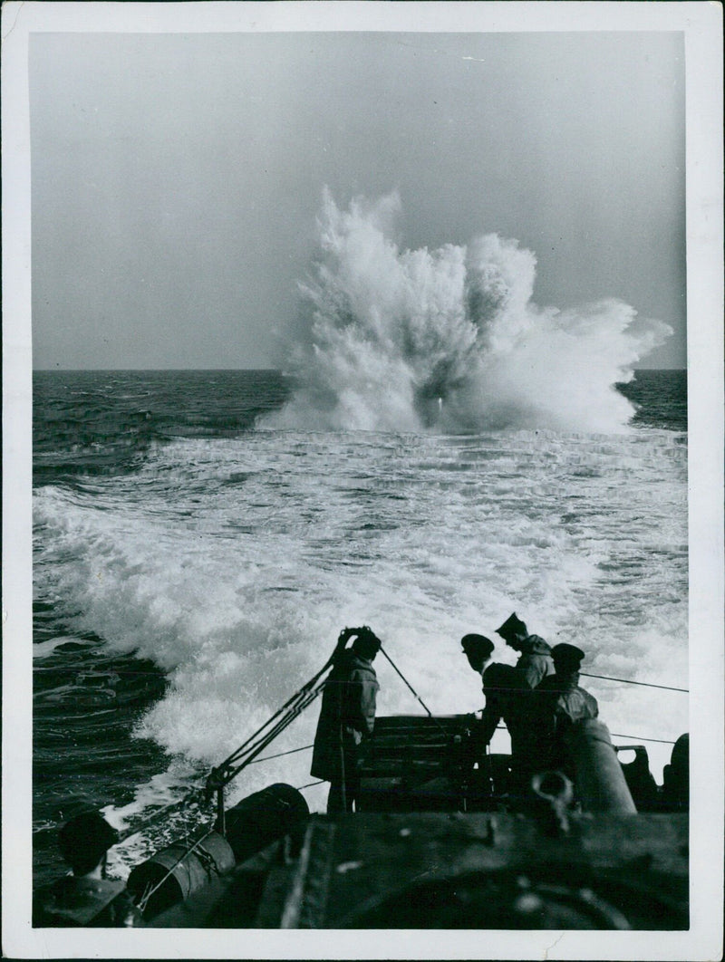 On board a British destroyer, a depth charge explodes with terrific force, dealing destruction to a U-boat during the Battle of the Atlantic in 1940. - Vintage Photograph