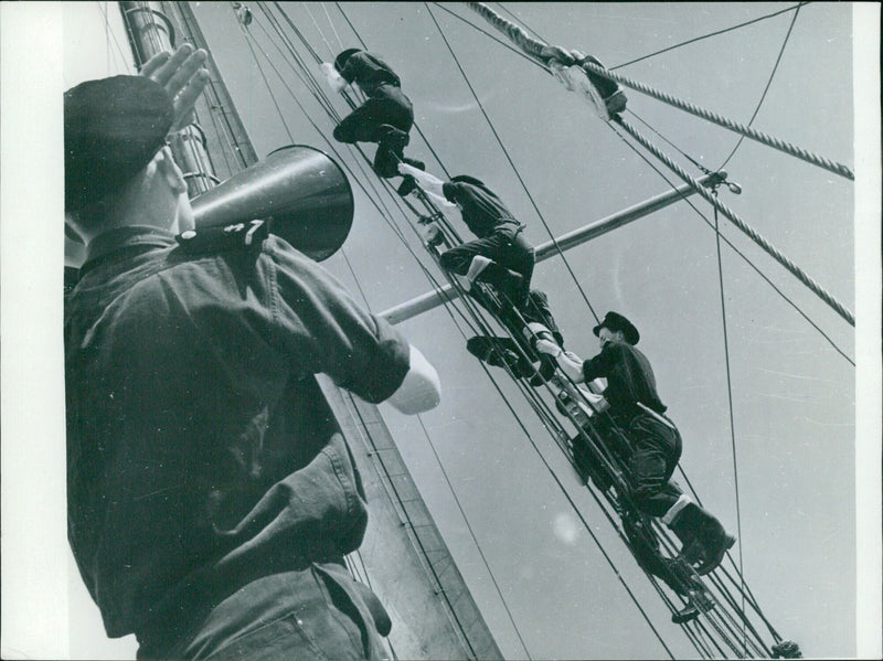 Cadets at the School of Navigation in Southampton learn the ways of the sea as they practice climbing the rigging on their own yacht. - Vintage Photograph