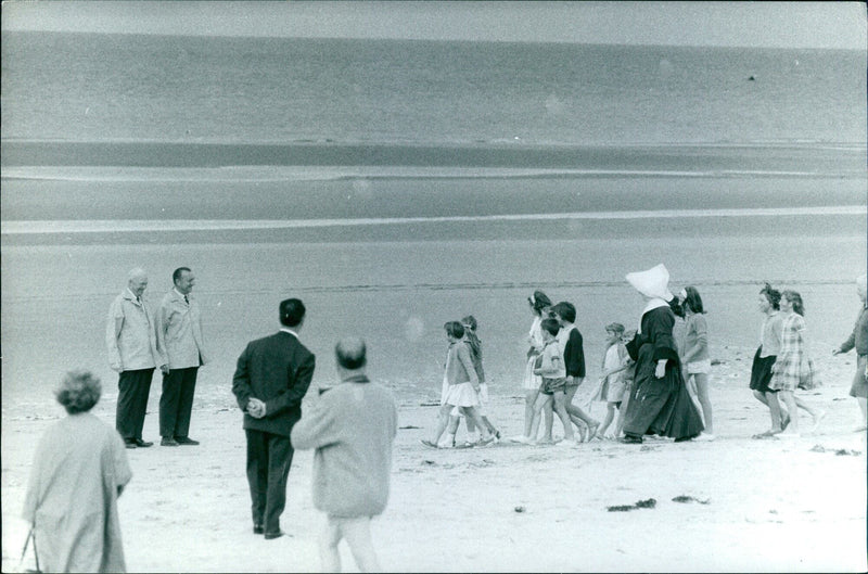 A group of people carrying umbrellas gather around a sign in the Avenue Frochot of Paris, France, on 2021-04-20. - Vintage Photograph