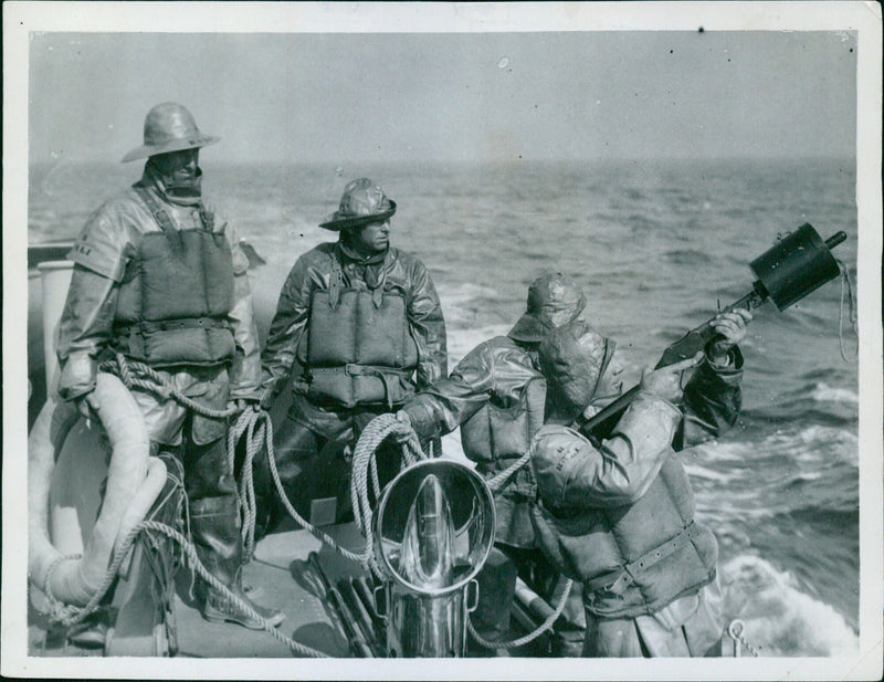 A British lifeboat crew fires a rocket gun in a daring rescue mission to save sailors from a sinking ship. - Vintage Photograph