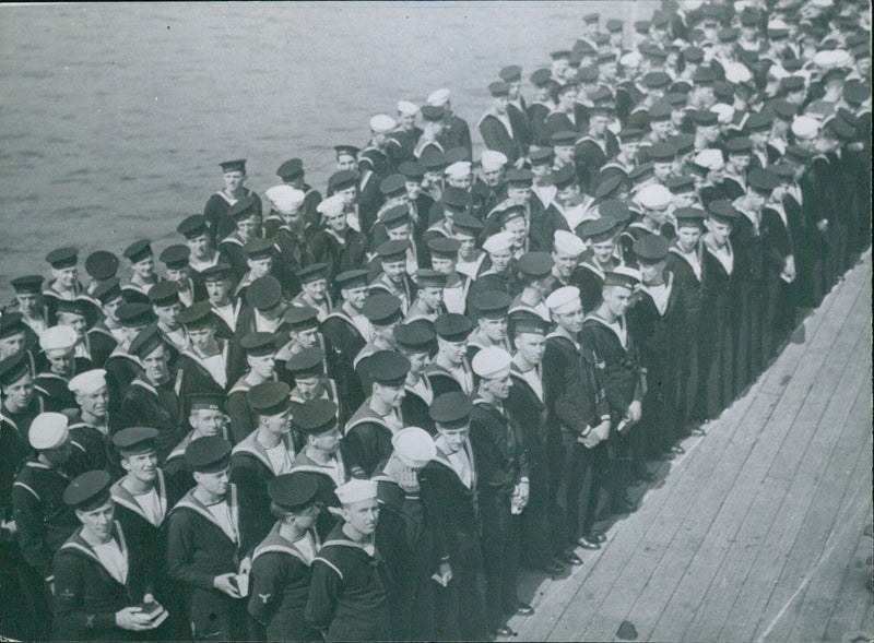 Sailors of the British and American navies come together to attend a church service on board HMS Prince of Wales on August 16, 1941. - Vintage Photograph