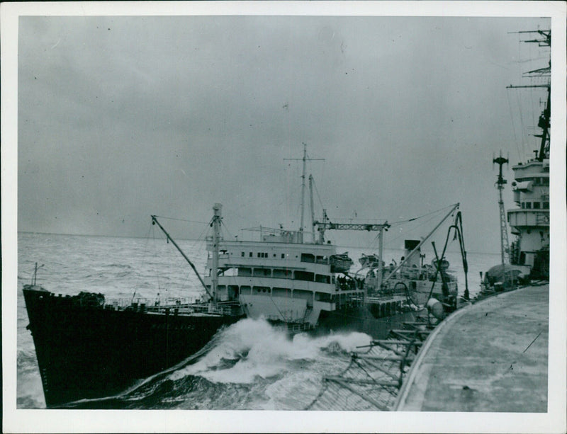 An English tanker pumps oil into an American cruiser off the Korean coast, aiding its mission. - Vintage Photograph