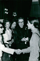 A woman poses with a sign that reads "IMS INTERNATIONAL TI CY ALBERTO AD A, 19 TEL. 2410752 MADRID-15" in Madrid, Spain. - Vintage Photograph