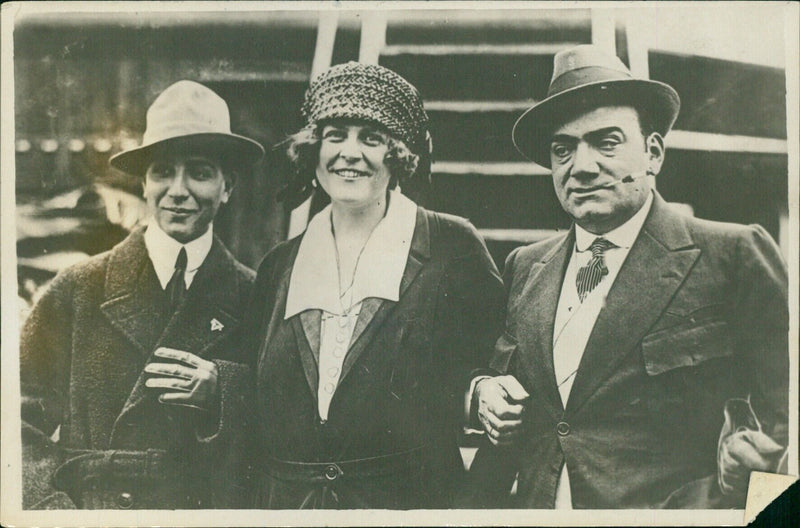 Opera singer Enrico Caruso stands with his Italian wife and American companion after a bomb exploded during a performance at Teatro San Carlo in Naples, injuring several people. Caruso escaped unharmed. Ⓒ Brokigt WELT-PRESS. - Vintage Photograph