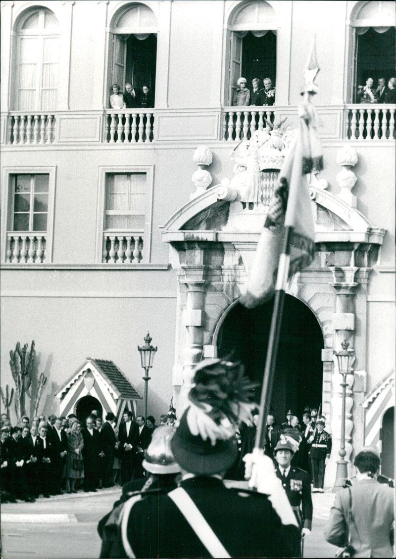 A group of people gathered in front of a Monaco telephone number and a Brussels address in November 1971. - Vintage Photograph