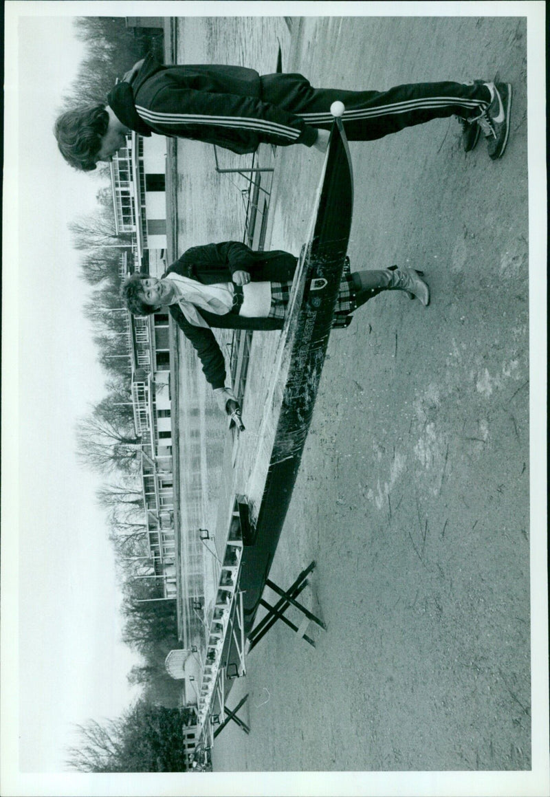 A woman eating lunch outside in a park on a sunny day. - Vintage Photograph