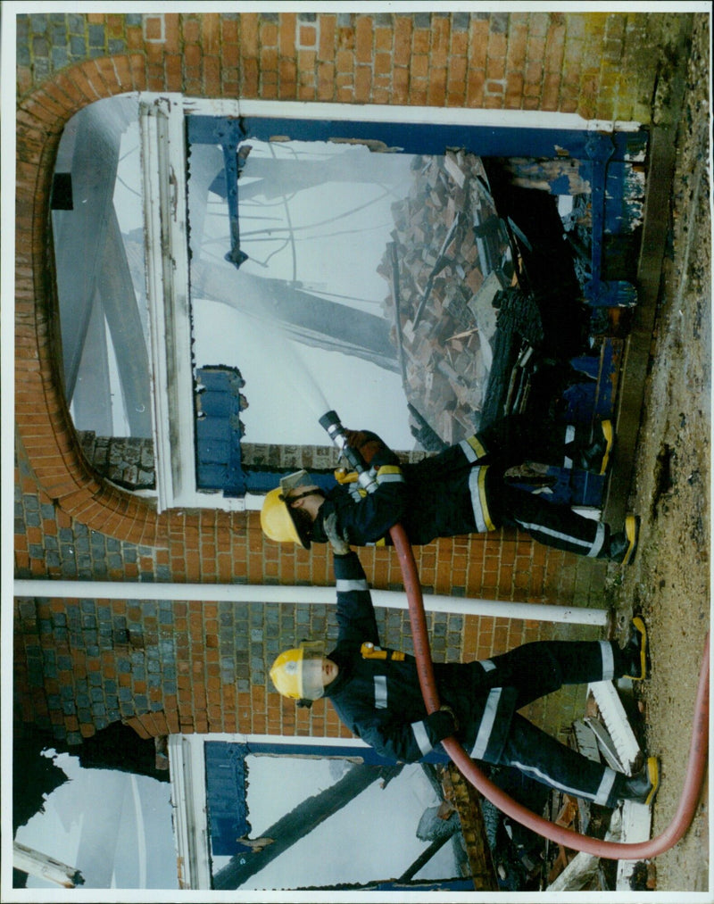 Oxford University rowing team members extinguish a fire at the boathouse. - Vintage Photograph