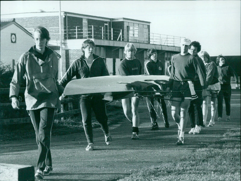 Members of the Radley College rowing squad take an eights boat down to the Thames. - Vintage Photograph