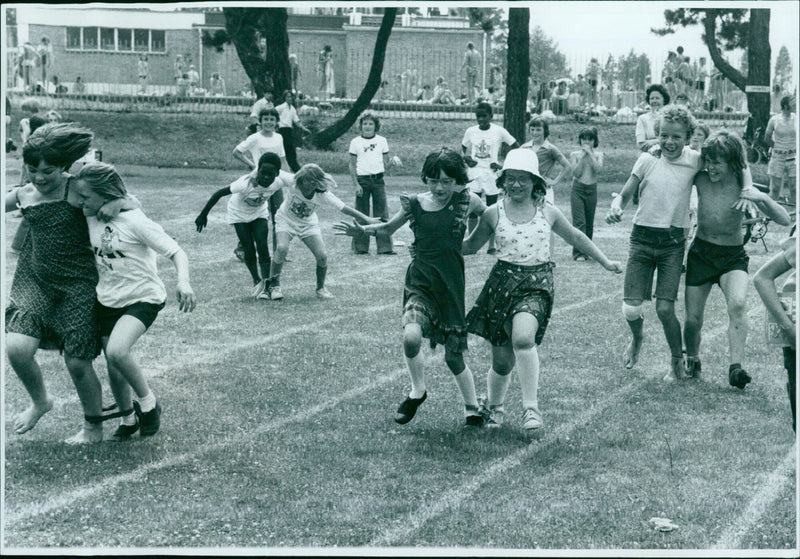 Participants take part in a three-legged race at De WIDE open day in July 1976. - Vintage Photograph