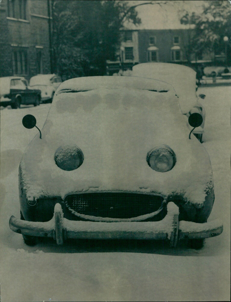 A snow-covered car is seen on the roadside in Oxford on February 20, 1969. - Vintage Photograph