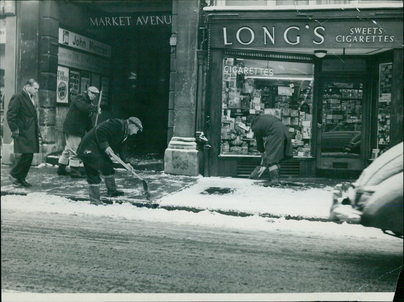 Workmen clearing snow in the high street this morning. - Vintage Photograph