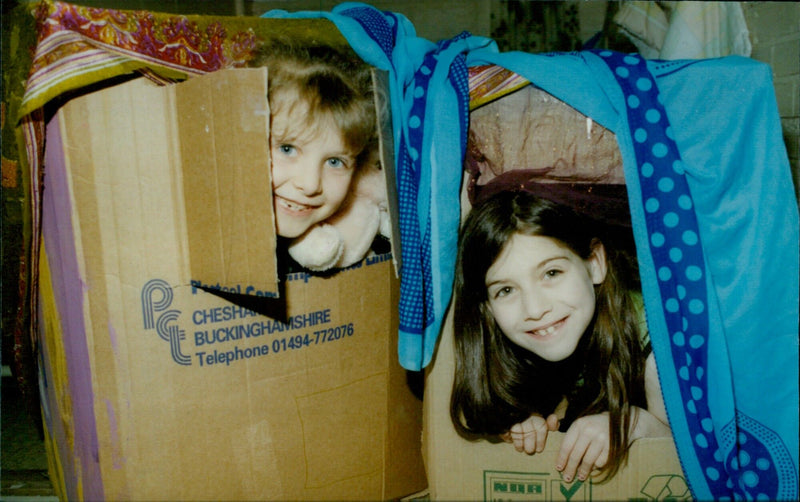 Two young girls enjoy a game of Connect4 while two others play in the boxes at St Andrews School's Headington Holiday Fun Club. - Vintage Photograph