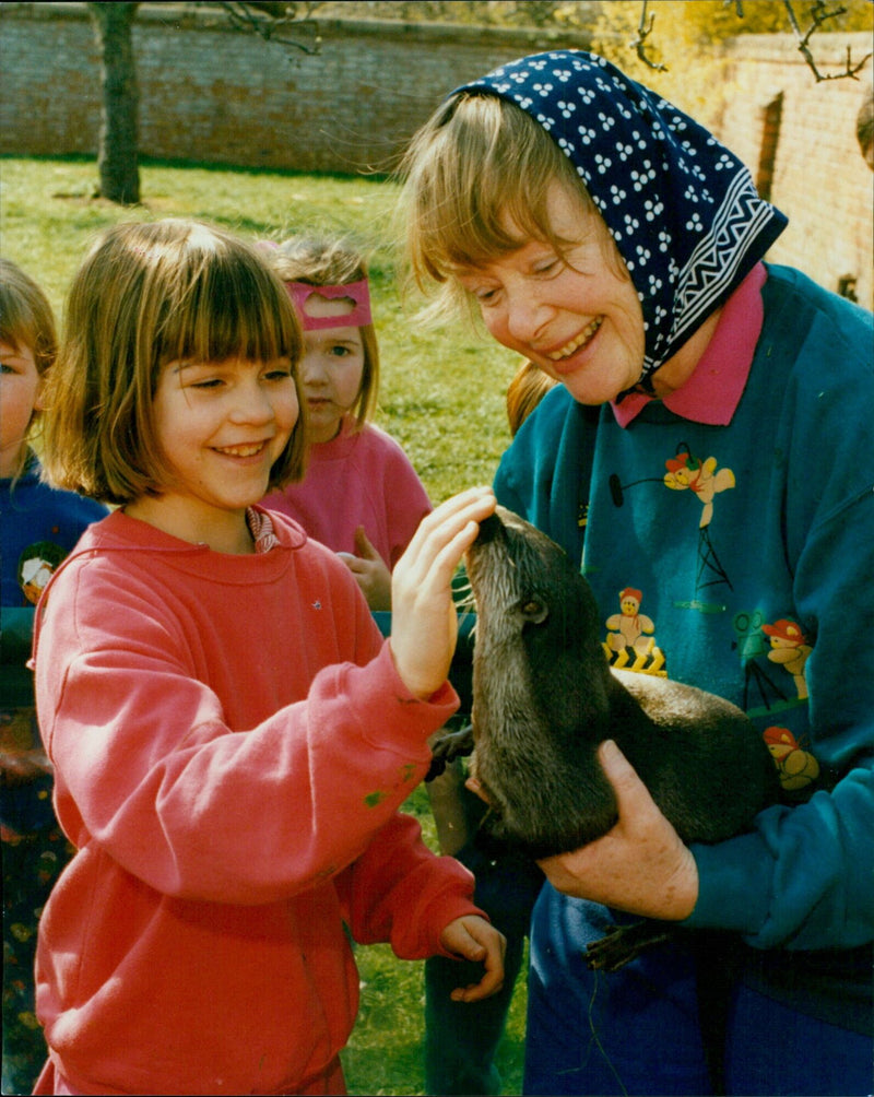 Mrs. Daphne Neville introduces Bee the otter to Ellen Hardy at St Aloysius School. - Vintage Photograph