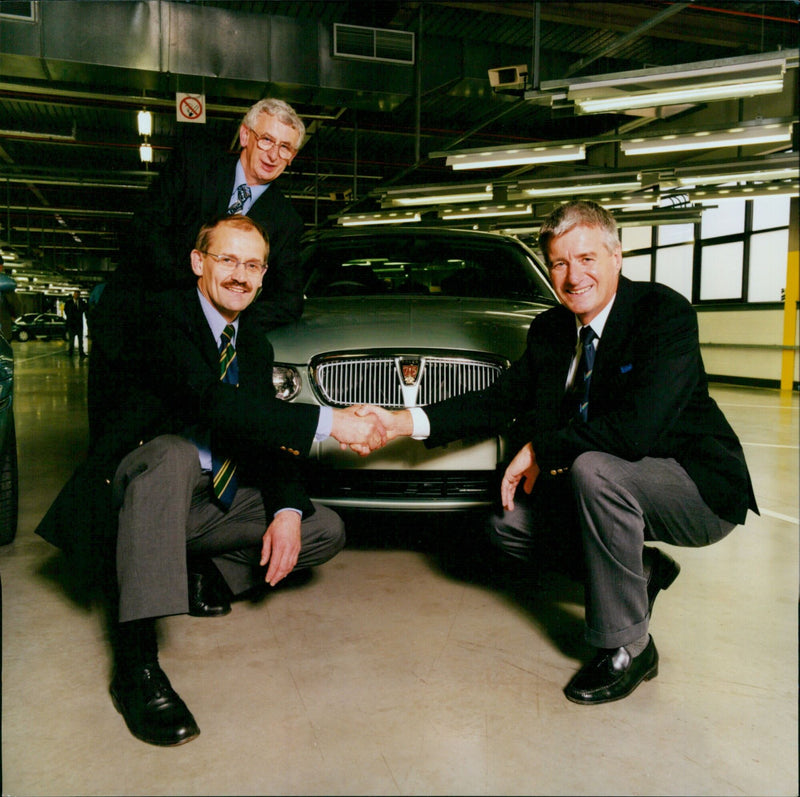 Alan Furey, Joseph Lorenz, and John Barlow pose with a Rover 75 at Rover Oxford. - Vintage Photograph