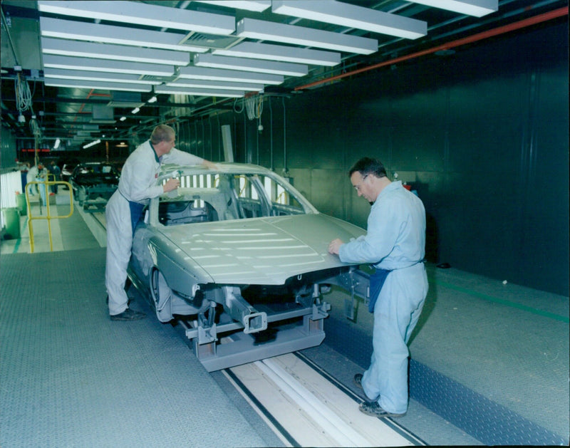 Workers assemble a Rover car in a factory in the UK. - Vintage Photograph